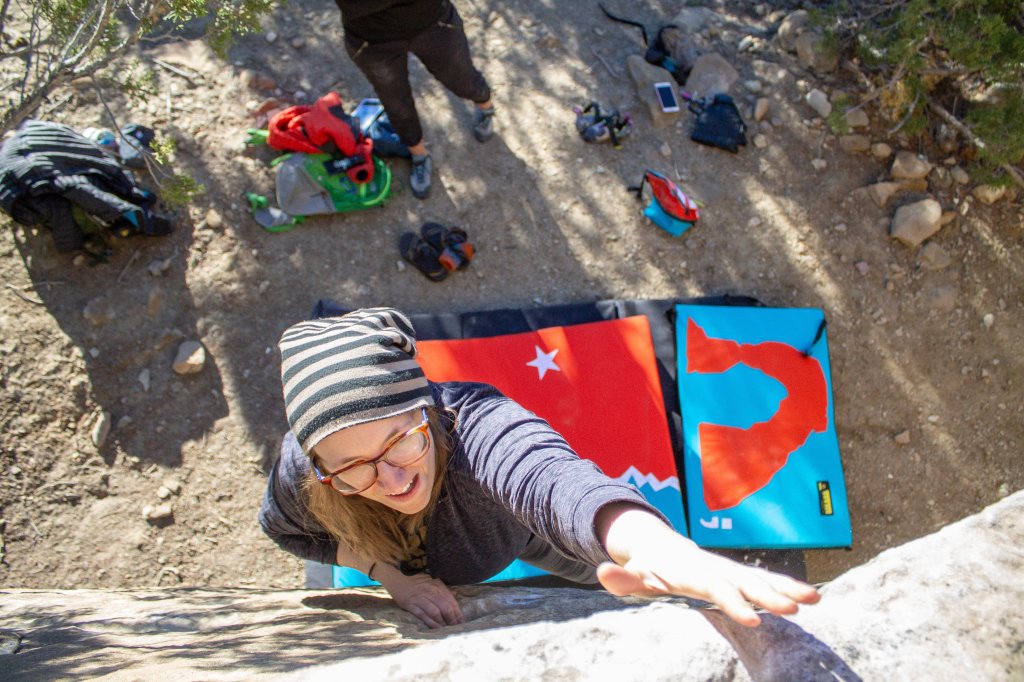 Anna bouldering in Joe's Valley with Organic Climbing crash pads below her.